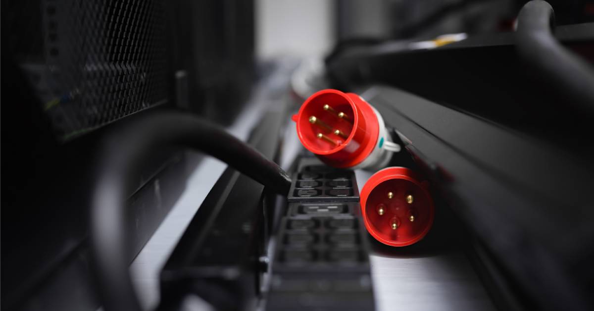 Two bright red 5-pin connectors in an automotive system. The two edges are resting on a multi-cavity connector base.