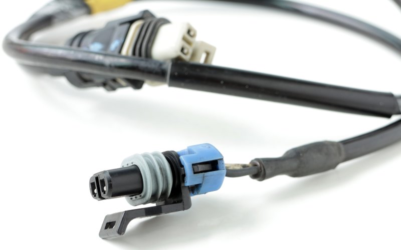  A long black cable with connectors at both ends. The white and black connector at each end have two distinct cavities.