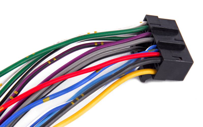 A black car connector with many colorful wires coming out of it lies on a plain, white background.