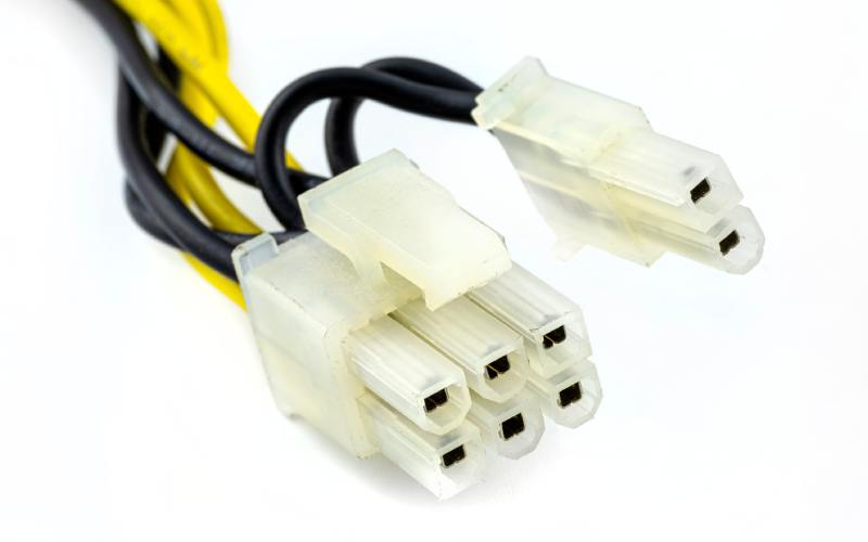A close-up of a 6+2 wire connector with black and yellow wires extending from it. The connector is against a white background.