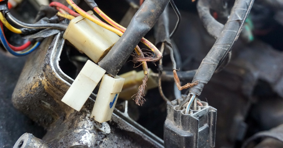 Automotive connectors inside a dirty vehicle. The cables and connectors are covered in dirt and dust.