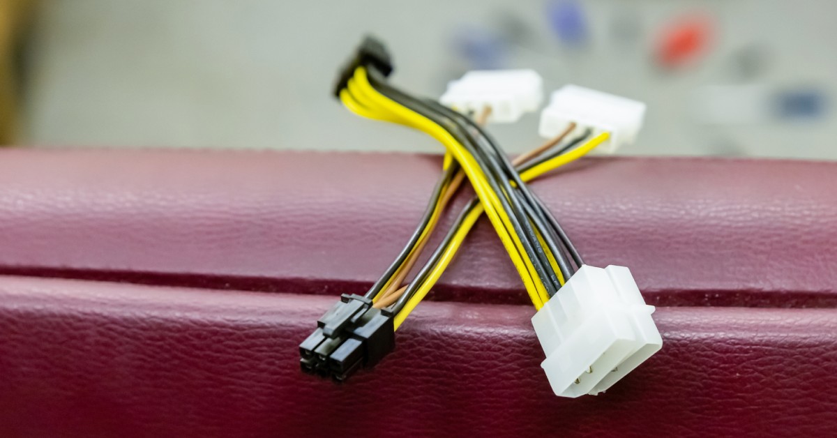 Two four-pin connectors stacked on top of a small ledge, each with multiple thin black and yellow cables.