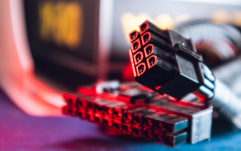 Two connectors lying on a black surface. One connector is an eight-pin design and the other has twenty-four pins.