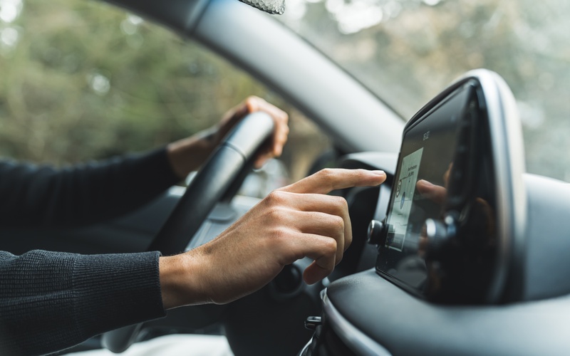 A small black video display with three wires behind it. One cable is red, another is yellow, and the third is white.